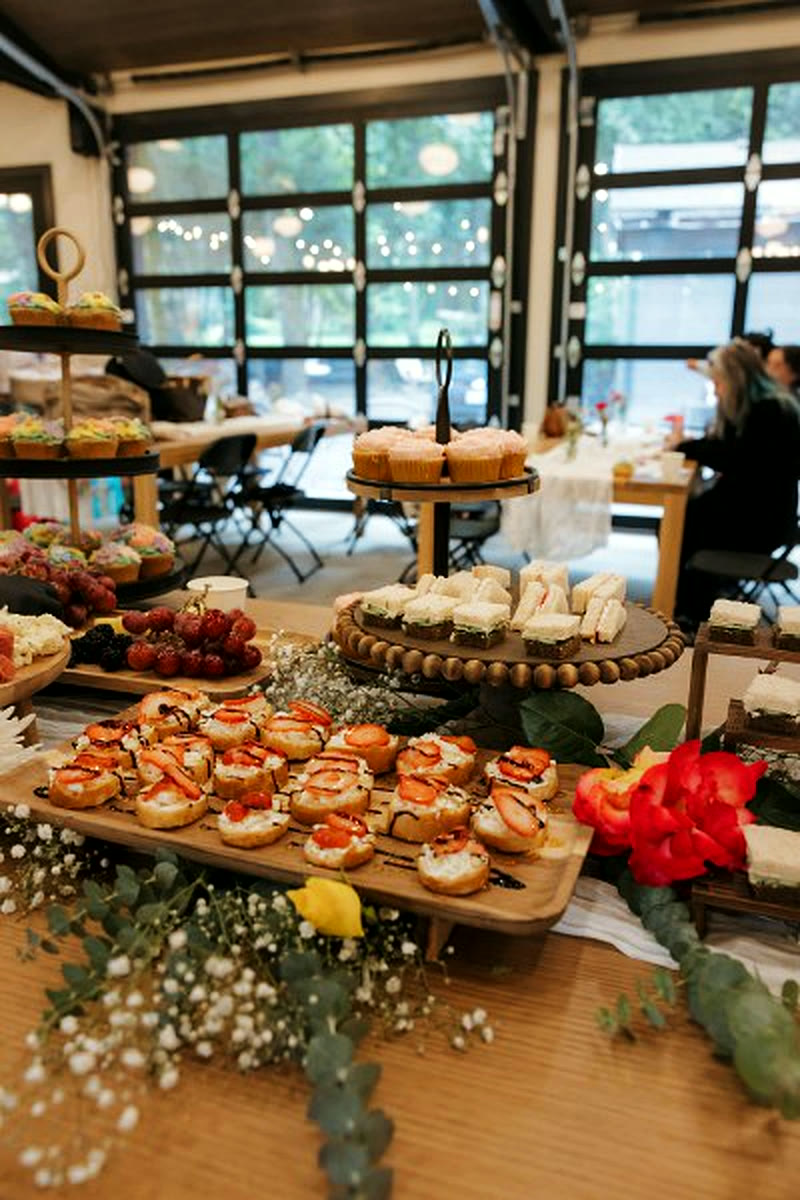 A grazing table of charcuterie and pastries laid out under the hall's glass doors