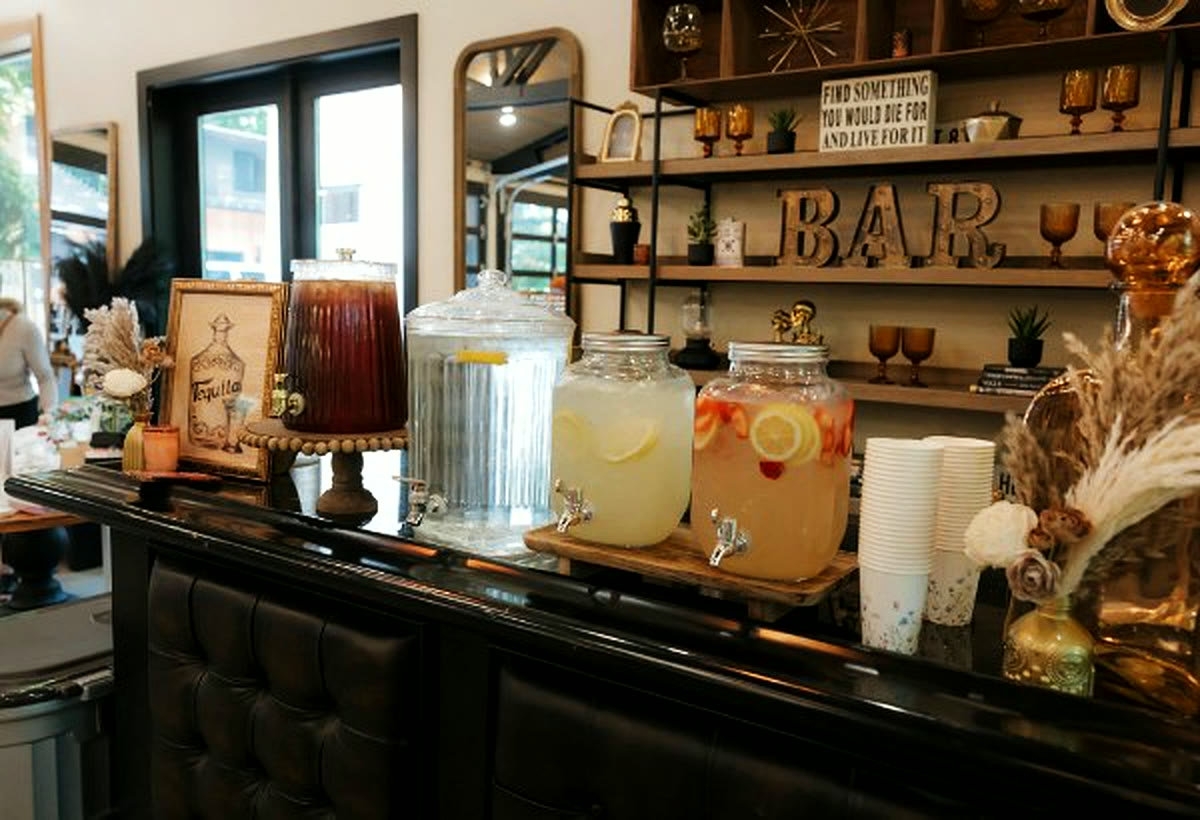 The bar with drink dispensers, glassware and the shelving wall behind