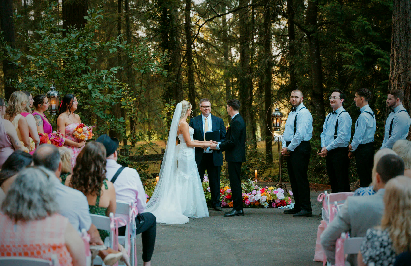 Vows at the front of the forest aisle, the wedding party lined up beside